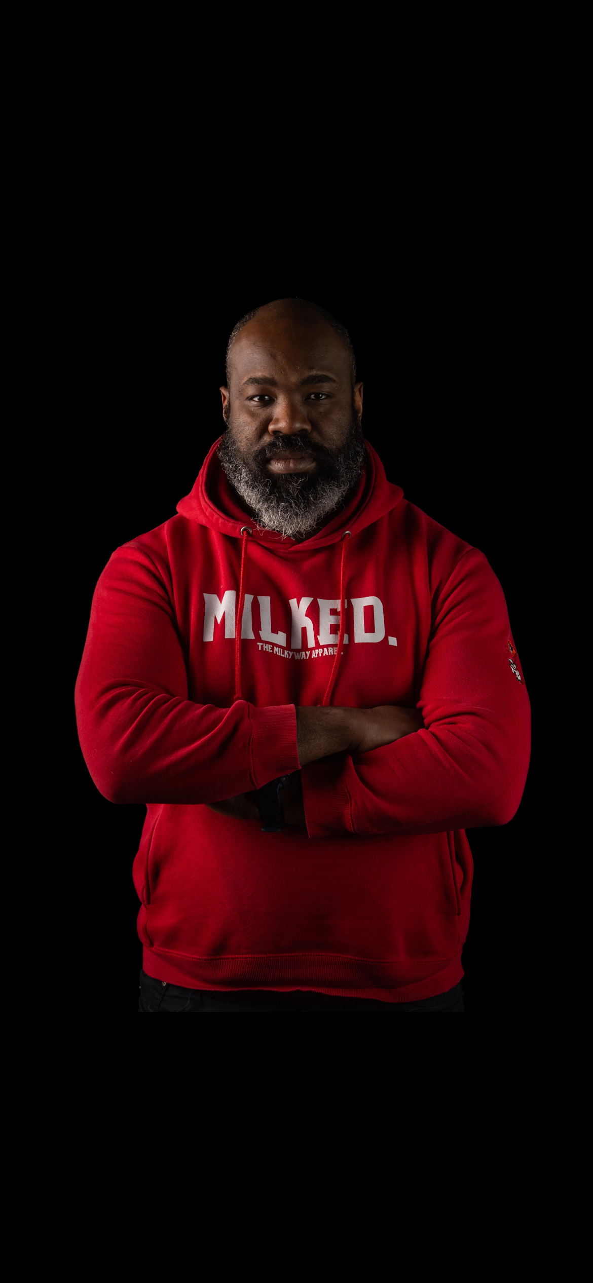 Man wearing a red hoodie with 'MILKED' text on a black background